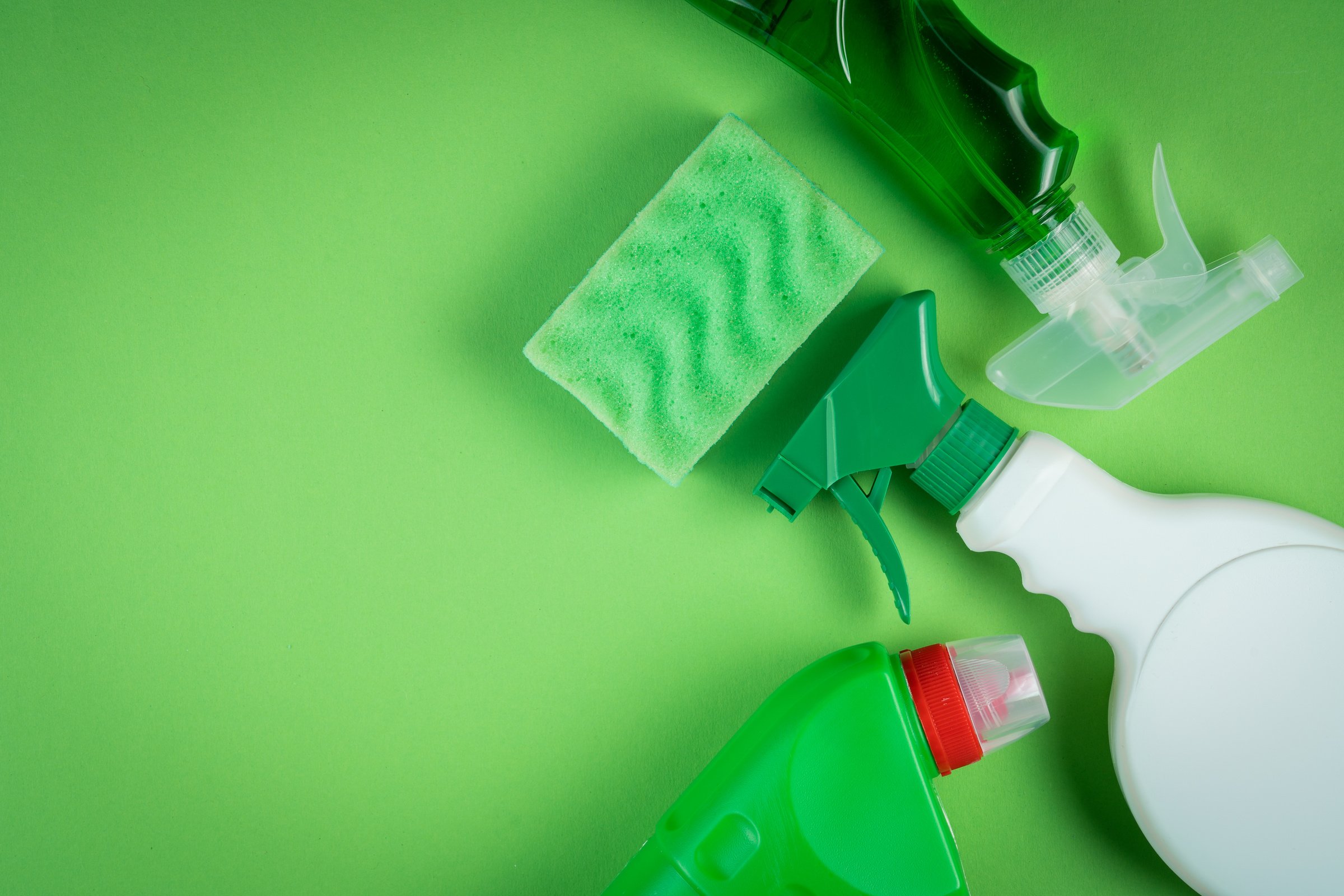 Cleaning supplies on green background